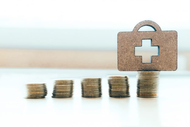 verzekering 2025 Koffer voor de verzekering zorg van 2025 met muntjes erbij