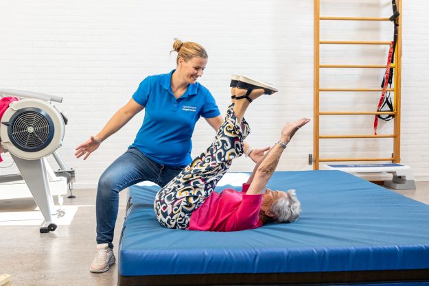 Valpreventie voor ouderen Valpreventie voor ouderen wordt gegeven door een fysiotherapeut in het blauw in de oefenzaal bij zesgehuchten