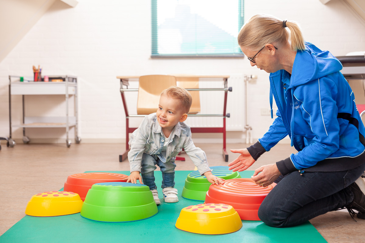 Kindje wordt geholpen met kinderfysiotherapie bij kind moeite met rennen en springen