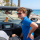 Man zit in zijn auto en rijdt langs het strand. Hij zit met pijn aan zijn rug, omdat hij last heeft van rugklachten op vakantie.